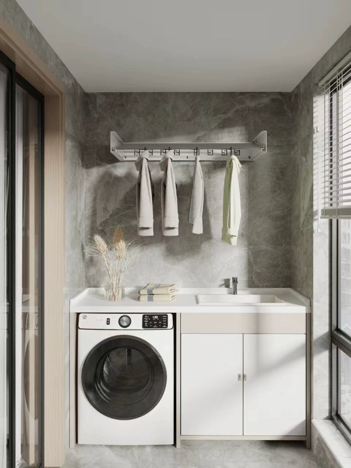 Wall-mounted folding clothes airer installed above laundry machines in a modern white laundry room.