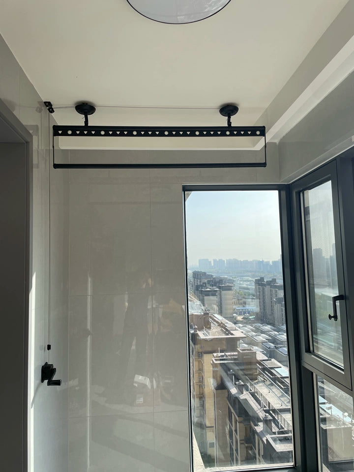 Modern black manual winch ceiling clothes rack in tiled high-rise balcony