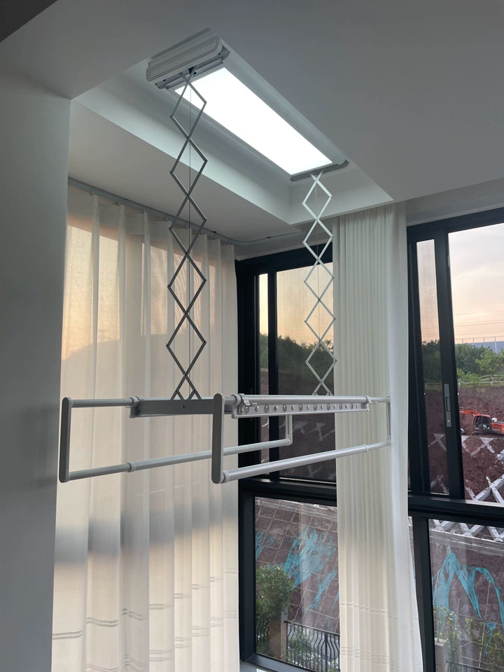 Electric ceiling clothes drying rack installed by windows, equipped with soft curtains.