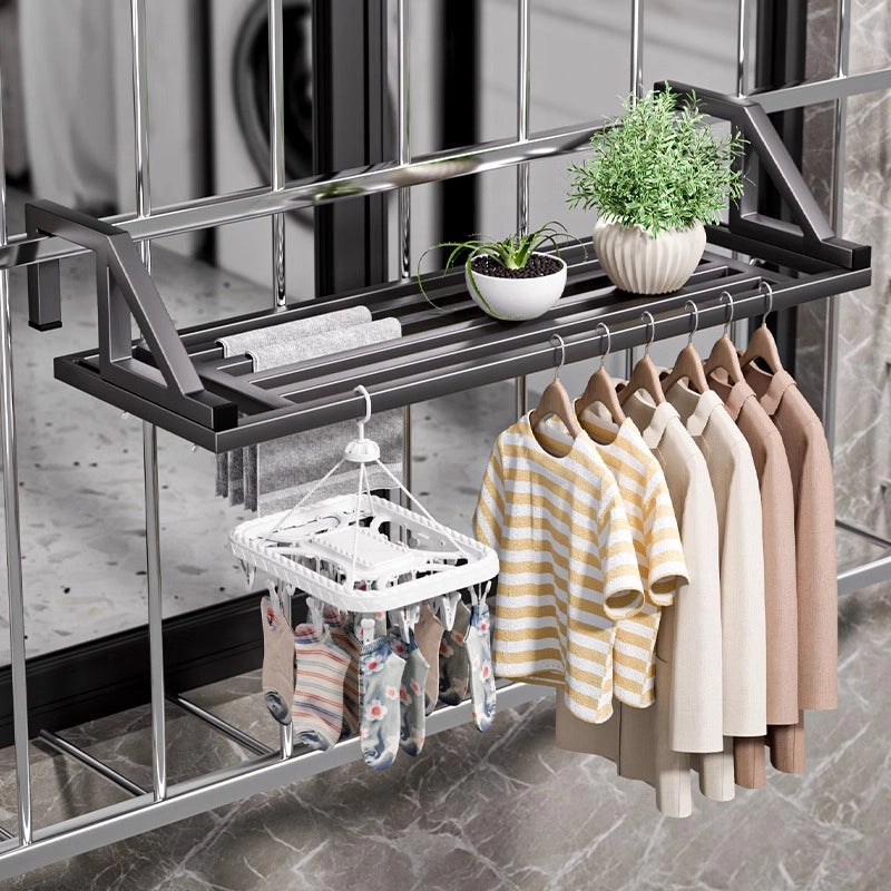 Multi-functional drying rack installed on a window security net, displaying drying of clothes and towels with added greenery.