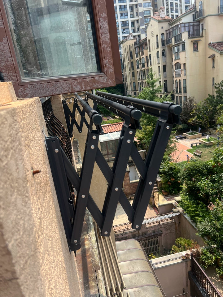 Wall-mounted retractable clothes drying rack installed on a high-rise balcony, showing sturdy support and outdoor durability.