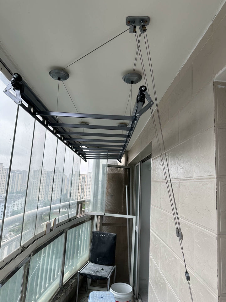 Manual clothes drying rack installed on a balcony under renovation.