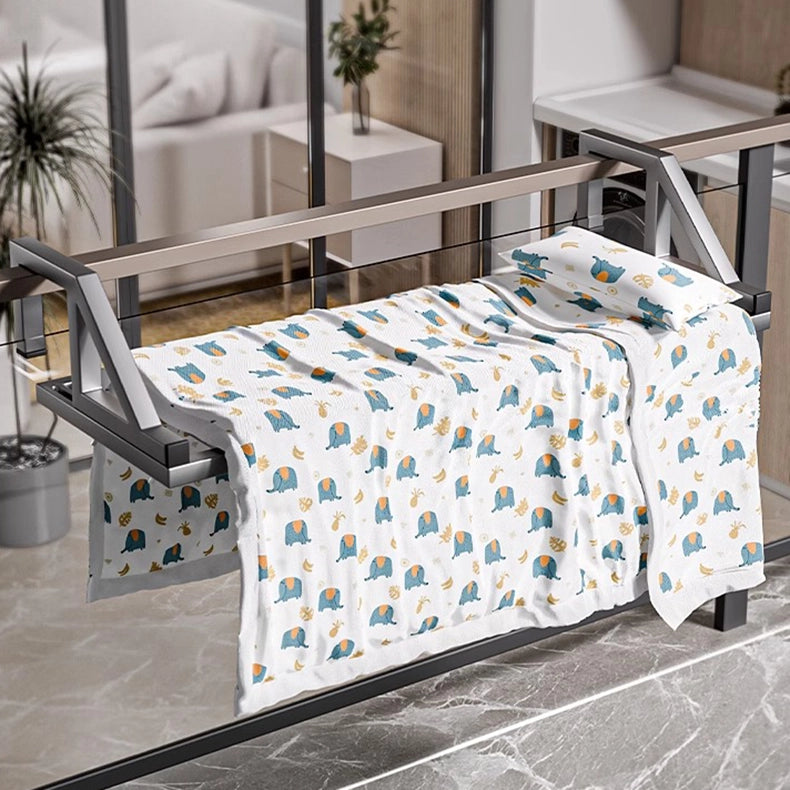 Balcony-mounted clothes drying rack displaying large quilt and pillow, showcasing vertical drying space.