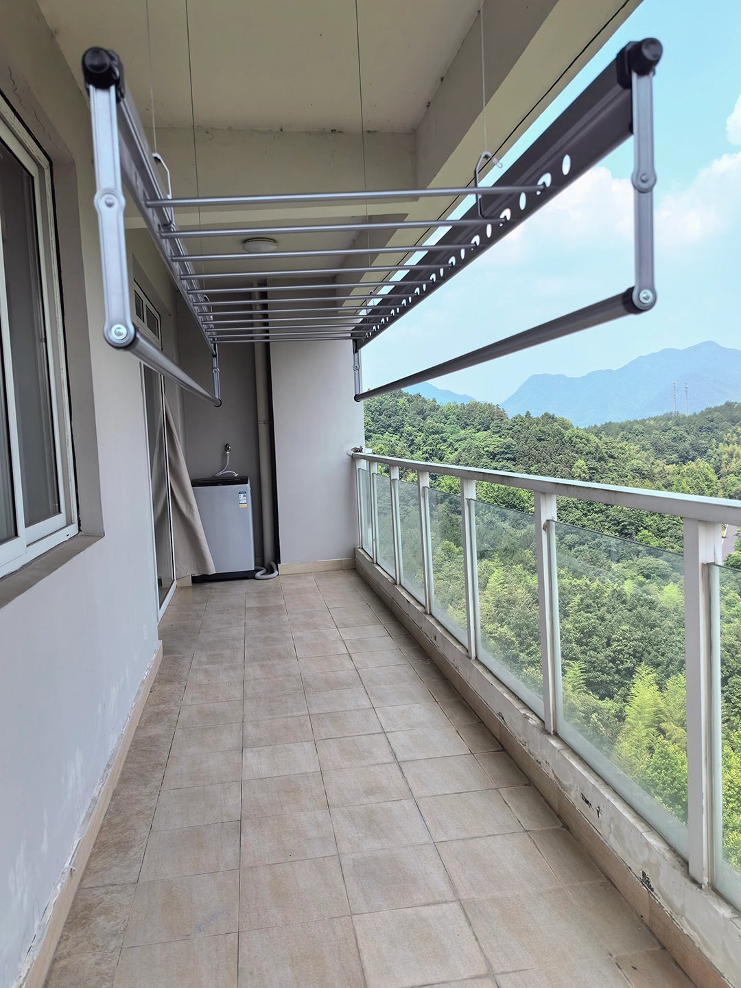 Square-Rod ceiling clothes airer installed along a long sheltered balcony with lower drying rods extended
