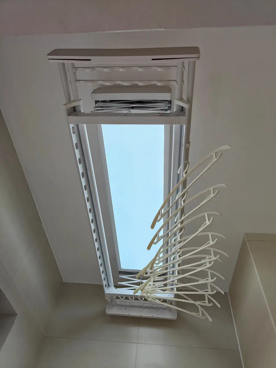 Moderner Wäscheständer von Easerack für die Deckenmontage in einem sonnendurchfluteten Waschraum mit ordentlich angeordneten Kleiderbügeln.