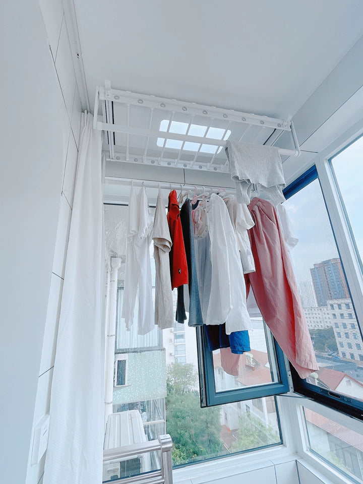 EaseRack V6 Ceiling mounted electric clothes drying rack installed on balcony with laundry hanging.