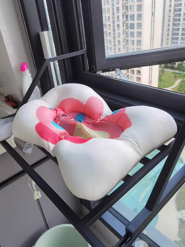 Séchoir à fenêtre Easerack utilisé pour sécher un coussin de bébé à l'intérieur.