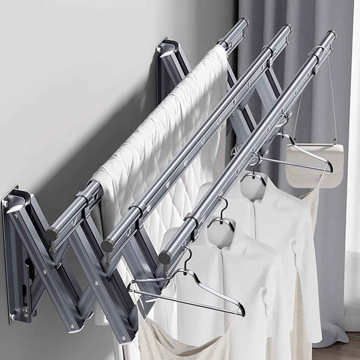 EaseRack wall-mounted retractable drying rack holding clothes and bedding across three drying rails.