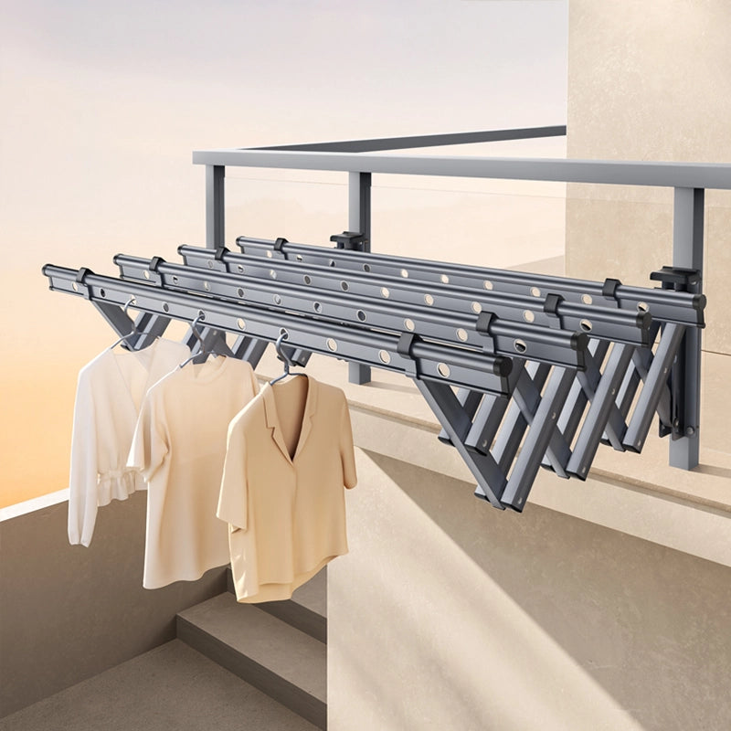 Retractable wall-mounted drying rack extended on a balcony with clothes hanging on the aluminum rods.
