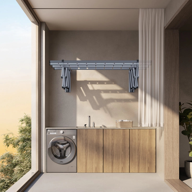 Wall-mounted retractable clothes drying rack installed above laundry counter top in a modern laundry room.
