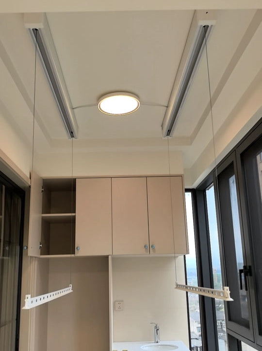 Electric clothes drying rack installed on a bright balcony, providing smooth lifting rods and convenient space-saving drying.