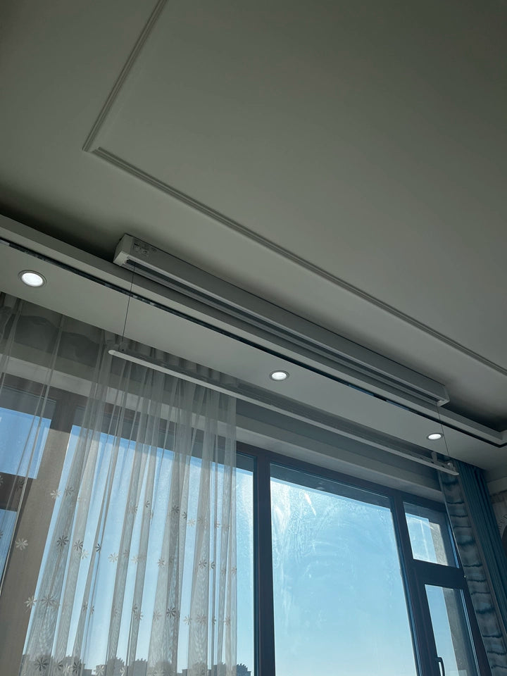 Ceiling mounted electric clothes drying rack with LED lighting, providing smooth lifting and efficient balcony drying.