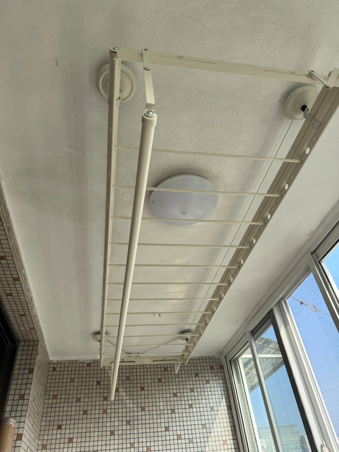 Ceiling clothes airer viewed from below, showing the crossbars and fold-down lower drying rods