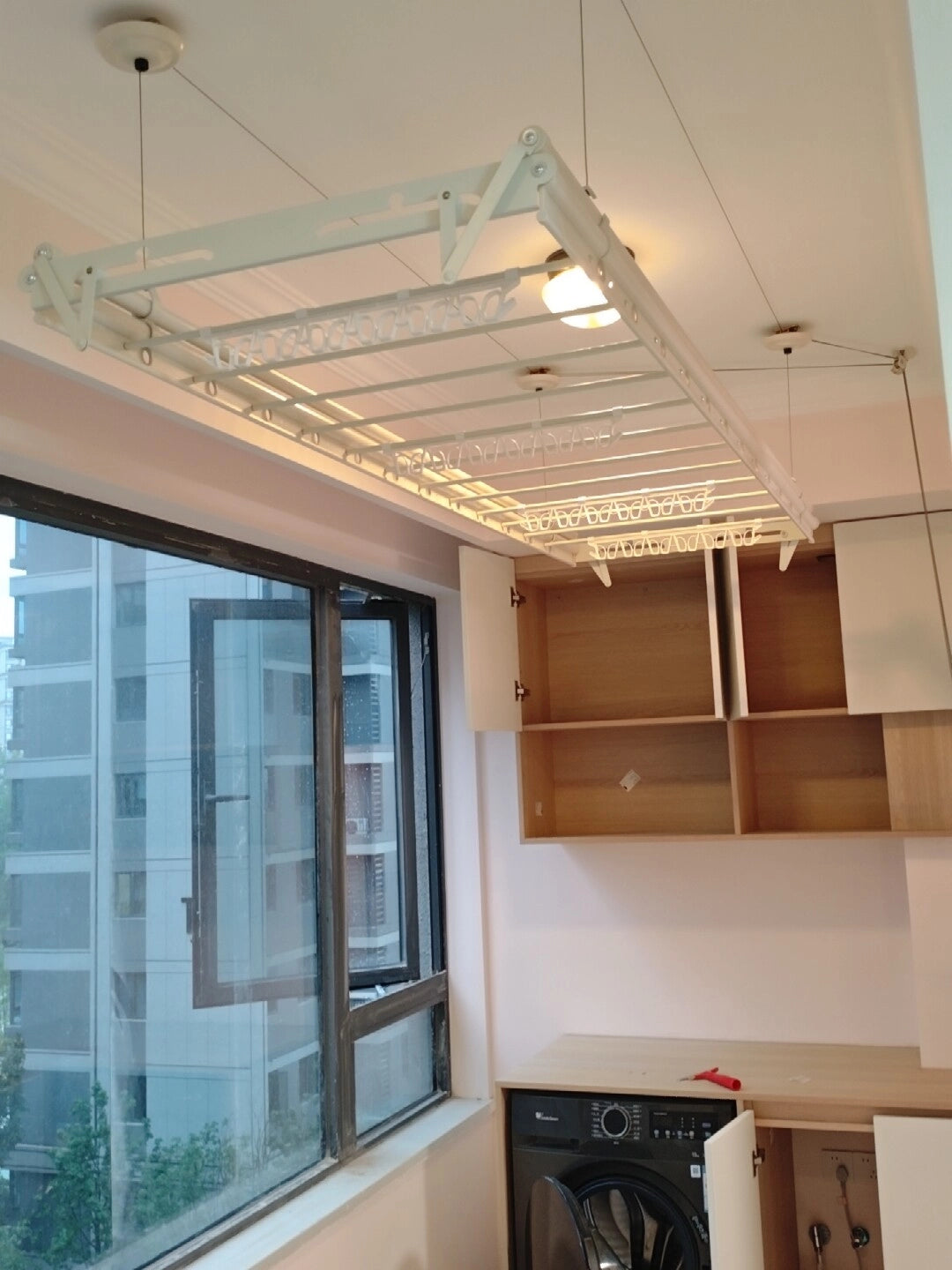 Extra-Wide ceiling clothes airer raised close to the ceiling in a home laundry space