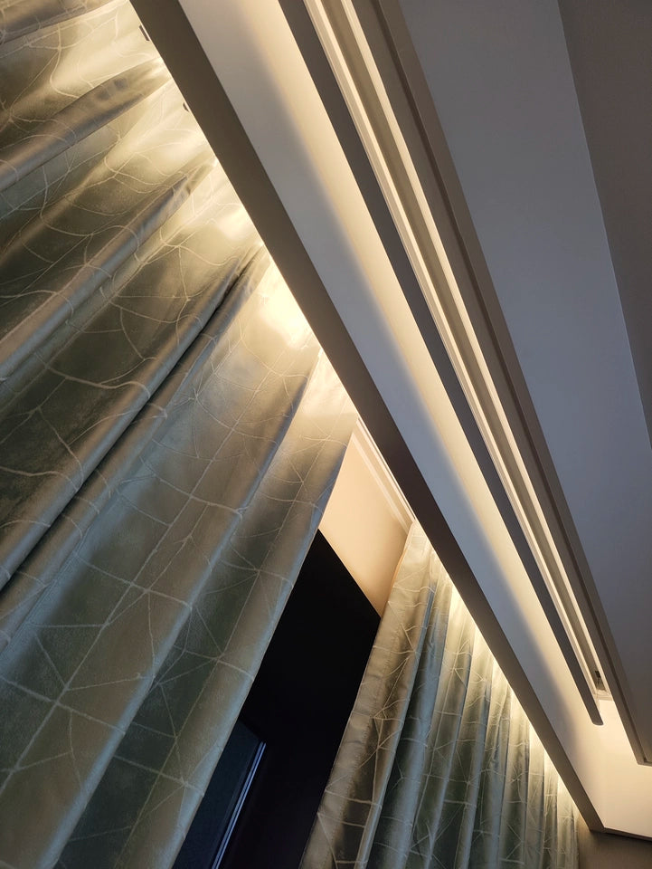 Hidden electric clothes drying rack integrated with ceiling lighting, blending seamlessly with curtains for modern interiors.